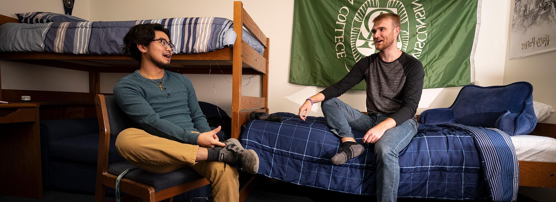 Two male students hanging out in a residence hall room